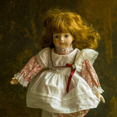 Poster - Portrait of a vintage doll with a beautiful dress on the brown background