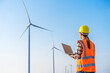 © geargodz - female engineer working with laptop computer against wind turbine farm