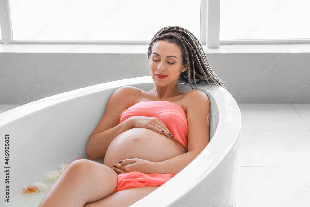 Beautiful pregnant woman taking bath at home