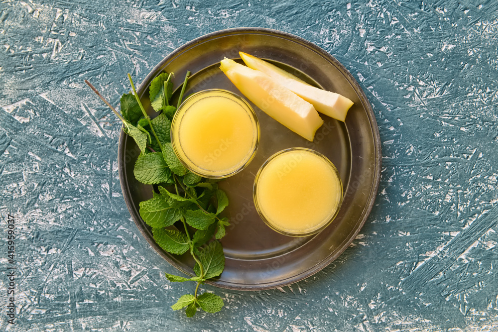 Glasses with melon smoothie on grunge background