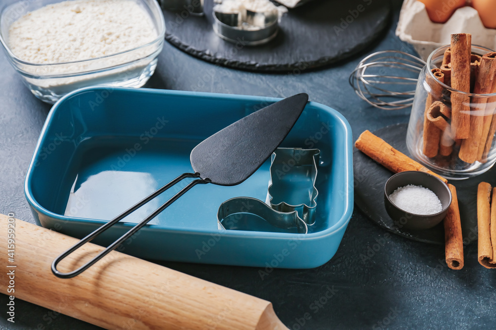 Set of kitchen utensils and ingredients for preparing bakery on dark background, closeup