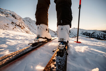 Mountaineer backcountry ski walking in the mountains. Ski touring in high alpine landscape. Adventure winter extreme sport. Detail boots.