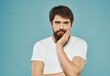 © SHOTPRIME STUDIO - guy in a white t-shirt on a blue background sad look model Copy Space