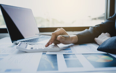 Businesswomen bookkeeper hand use calculator and laptop doing account for paying tax on white desk in working office