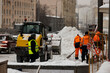 © Serhii - Workers with shovels and special equipment remove snow from the streets of the city after a snowfall. Snowfall in Moscow. Soft focus.