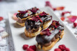 creamy chocolate eclair with edible flowers, rose petals and freeze dried raspberries 