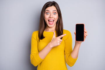 Wall Mural - Photo of impressed brunette nice lady hold point telephone wear yellow sweater isolated on grey color background