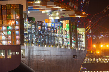 Container vessel ship in port quayside during loading process at night