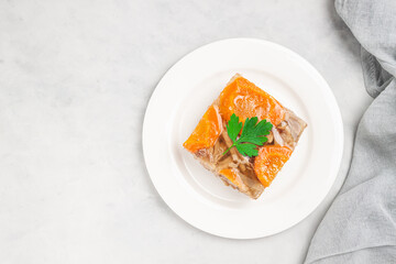 Jellied meat with horseradish on grey table