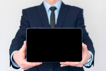 Businessman in a suit holding a tablet computer with isolated screen. Presentation mock-up