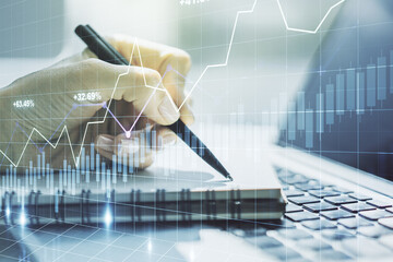 Double exposure of abstract creative financial chart with hand writing in notebook on background, research and strategy concept