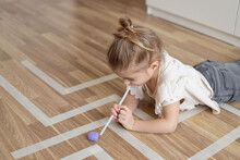 Child Little Girl Playing Homemade Game With Straw And Pom Pom For Better Articulation.
