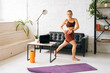 © dikushin - Sportive fit young woman with perfect athletic body wearing sportswear doing working out exercising standing barefoot on floor. Concept of healthy lifestyle and physical activity at home.