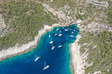 Wall Mural - Aerial drone shot of yachts at Stiniva cove of blue Adriatic sea on Vis Island in Croatia summer