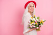 © deagreez - Profile side view portrait of pretty cheerful grey-haired granny holding floral tulips romantic event copy space isolated over pink pastel color background