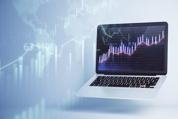 Online forex chart analysis with opened laptop with financial candlestick on display at abstract stock market background. Double exposure