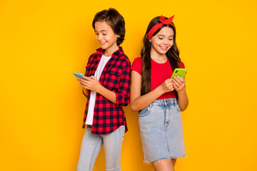 Canvas Print - Photo of two children hold telephone look screen wear red casual clothes isolated yellow color background