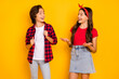 © deagreez - Portrait of positive boy girl look each other speak explain toothy smile isolated on yellow color background