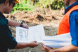 © Wasan - Group of contractors discuss land improvement planning for construction.