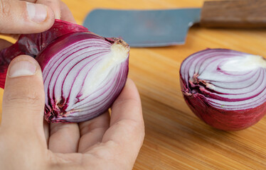 Wall Mural - Hands peeling a piece of purple onion