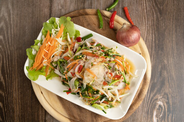 Seafood Spicy Salad on the wooden background ready to eat