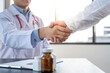 © crizzystudio - Doctor shakes hands with his patient in the office, after successful treatment of specialty and delighted patients returned home, a handshake concept to congratulate.