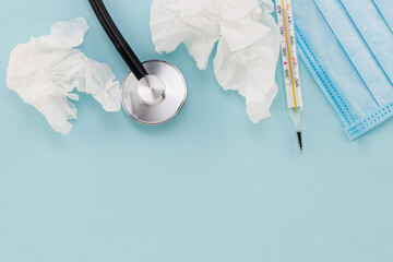 Medical mask, thermometer, stethoscope on a blue background. Virus concept