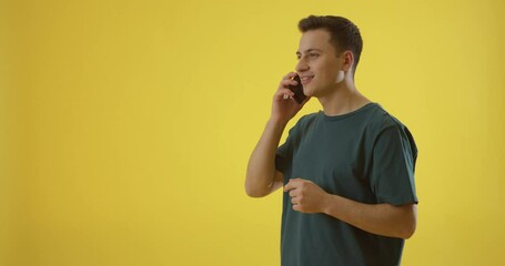 Canvas Print - Young man making order by phone, getting parcel and showing thumb-up on color background