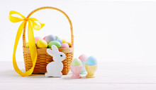 Basket With Flowers And Decorated Eggs For The Easter Holiday. Colorful Eggs In Egg Stands. Homemade Rabbit Cookies