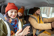 © pressmaster - Happy young mother in warm winterwear looking at screen of smartphone in car
