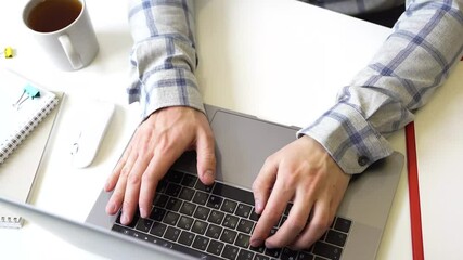 Wall Mural - a man works with a laptop, types text on the keyboard, working office