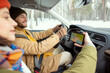 © pressmaster - Happy young active man in warm winterwear looking at map on screen of smartphone