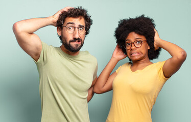 Wall Mural - multiracial couple of friends feeling stressed, worried, anxious or scared, with hands on head, panicking at mistake