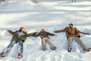 Sticker - Cheerful young man, his wife and their cute little daughter lying in snowdrift