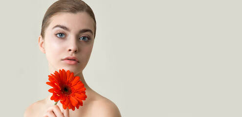 Wall Mural -  Beautiful young woman with perfect skin and flower.