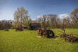 © Martina - Old rusty farm equipment and tractor by a barn