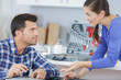 © auremar - male worker repairing with young woman standing in kitchen