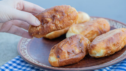 Hand taking a fresh delicious homemade pastry on a brown plate