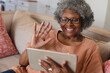 © Wavebreak Media - African american senior woman smiling and waving while having a video call on digital tablet at home
