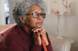© Wavebreak Media - Close up of thoughtful african american senior woman holding walking stick at home