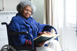 © Wavebreak Media - African american senior woman reading a book while sitting on wheelchair at home
