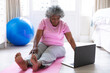 © Wavebreak Media - African american senior woman using laptop while practicing yoga at home