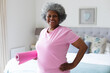 © Wavebreak Media - Portrait of african american senior woman smiling while holding yoga mat at home
