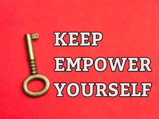 Phrase KEEP EMPOWER YOURSELF written on red background with vintage key. KEY concept.