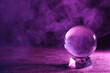 Crystal ball on table and smoke against dark background, space for text. Predictions of future