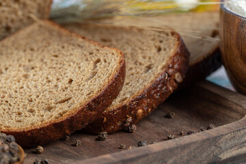 Wall Mural - Slices of brown bread with pepper on a wooden board