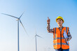 © geargodz - female engineer working  against wind turbine farm