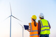 © geargodz - engineer team working with laptop computer against wind turbine farm