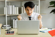 © SHUTTER DIN - young businessman sitting cheering for football on the laptop