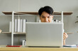 © SHUTTER DIN - young businessman sitting cheering for football on the laptop